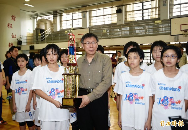  台北市長柯文哲16日出席北投國小女籃參加教育盃比賽18連霸頒獎活動，頒贈獎座並勉勵球員。（記者方賓照攝）