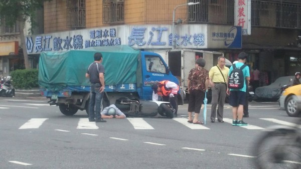 機車騎士被壓在車底下，場面驚險。（記者王冠仁翻攝）