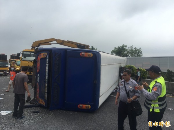 一輛滿載江蘇來的中國遊客的遊覽車，疑似為閃避前方車輛，不慎衝撞右側護欄後，側翻橫躺在3線車道上。（記者鄭鴻達攝）