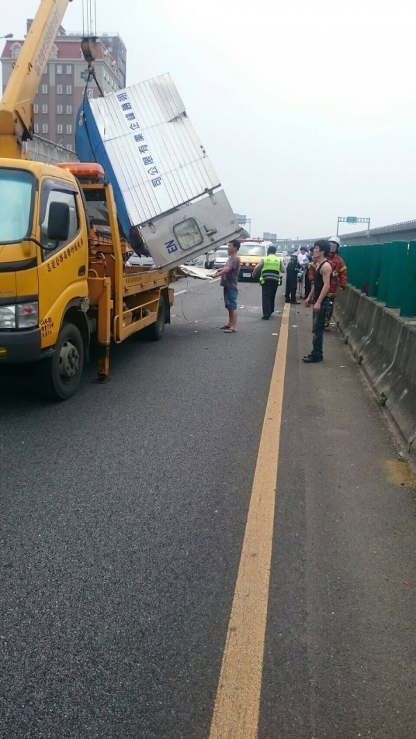 小貨車國道翻覆，張姓駕駛命大雙手割傷拒送醫。（記者李容萍翻攝）