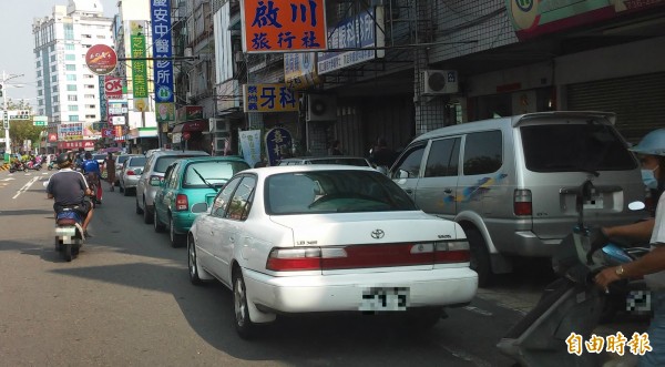 屏東市部份路段違規併排停車情形嚴重，警方今天加強勸導及取締。（記者李立法攝）
