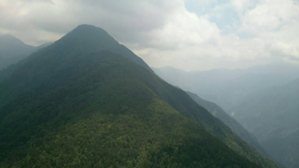 直升機進入山區嘗試吊掛受困山友，但因雲層太厚無功而返。（記者劉濱銓翻攝）