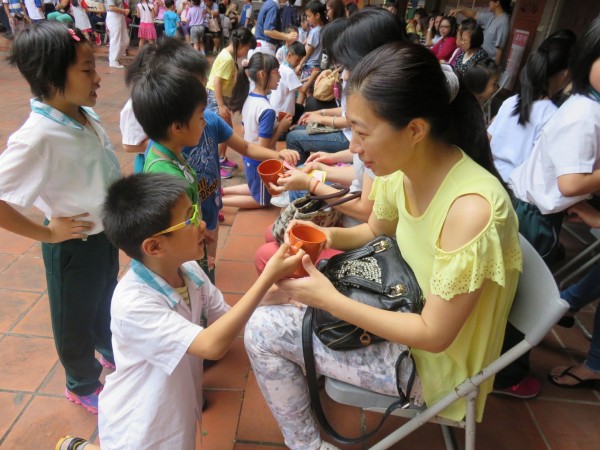 鶯歌區永吉國小學童親手奉桔茶給母親，酸甜的滋味搭著孩子輕柔的捶背，讓媽媽們感動不已。（永吉國小提供）