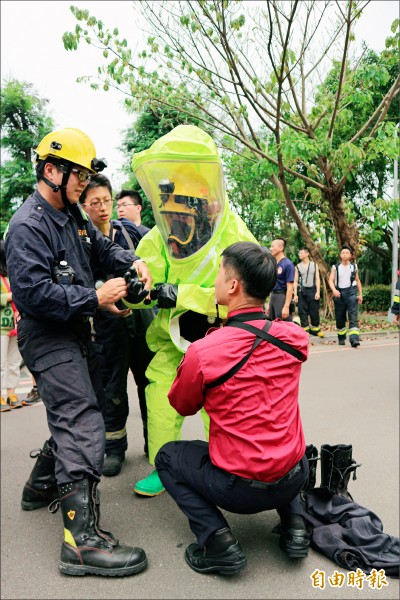 消防人員穿著A級防護衣進入實驗室。（記者陳薏云攝）