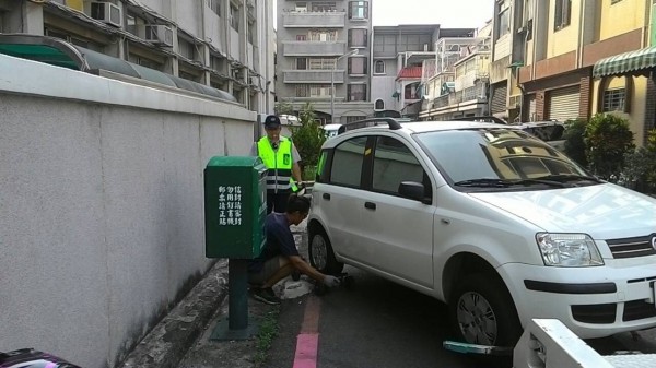 南市一分局警方拖吊德光中學圍牆邊違停車輛，校方守衛指他已出面向警方求情，警方仍堅持拖走車子。（記者王俊忠翻攝）