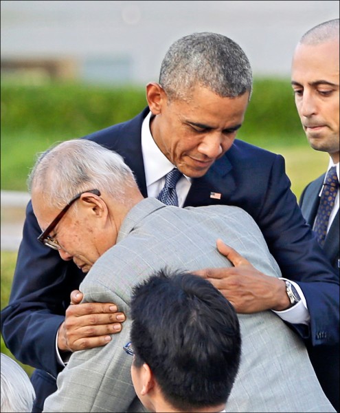 美國總統歐巴馬二十七日在日本首相安倍晉三陪同下，於廣島和平紀念公園內的原爆罹難者慰靈碑前獻花。歐巴馬並擁抱廣島原爆受害者森重昭。（美聯社）。