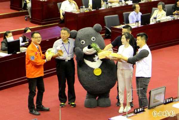 經過一番折騰，台北市長柯文哲（左二）答應提供世大運吉祥物熊讚（中）薪水以及各項福利措施。（記者郭逸攝）