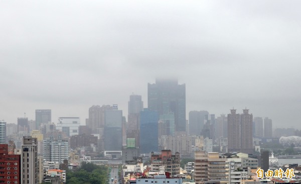 受西南氣流影響，氣象局發佈今天下午1點30分再發布大雨及豪雨特報，其中高雄市、屏東縣例為豪雨特報警戒區。從上午10點25分對全台15縣市發布大雨特報，至下午2點30分屏東車城累積雨量已有134毫米。目前高雄市區出現間歇性降雨，雲層偏低，地標85大樓一半被雲遮蔽。（記者黃志源攝）