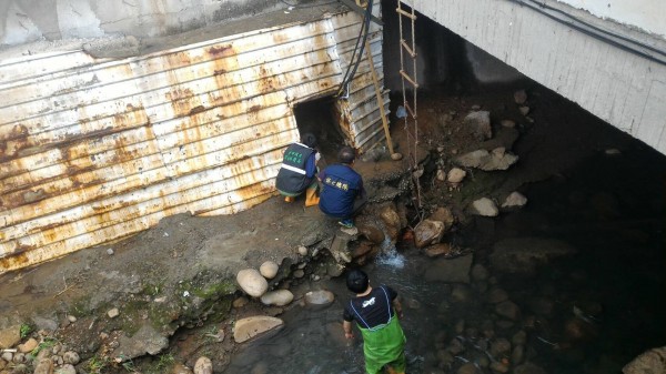 警察與環保人員爬入排水涵洞內，採集電鍍工廠排放的廢水。（記者張瑞楨翻攝）