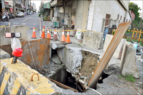 嘉義市國華街與長安街口的下水道疏濬工程洞口，施工月餘未完工，民眾認為人車經過危險，拍照上網諷其為「人工天坑」。（記者王善嬿攝）