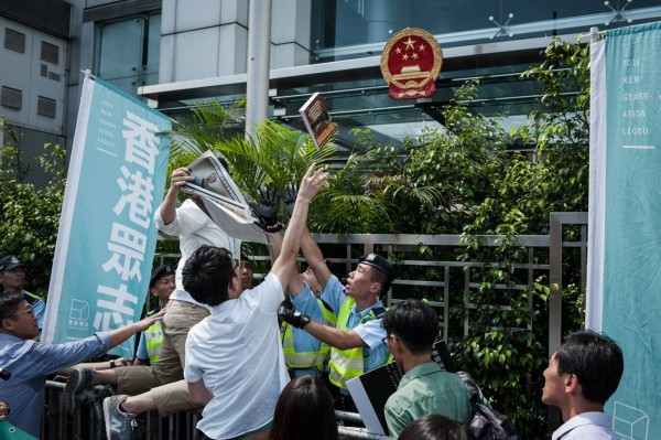 聲援銅鑼灣書店店長林榮基，「香港眾志」黨丟書進中國中央政府駐香港聯絡辦公室大樓抗議。（圖擷自香港眾志臉書）