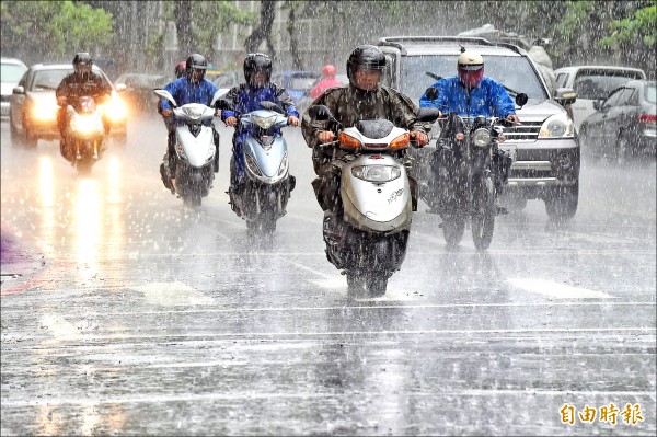 大台北地區下起午後雷陣雨，雨勢又大又急，機車騎士紛紛穿上雨衣行車。（記者劉信德攝）