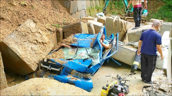 新北市午後一場大雨，三峽山區出現土石流，紫微路產業道路擋土牆被沖倒，混凝土塊擊中一輛小貨車，幾乎壓扁車頭，車內有三人，兩人傷重不治，駕駛送醫撿回一命。（中央社）