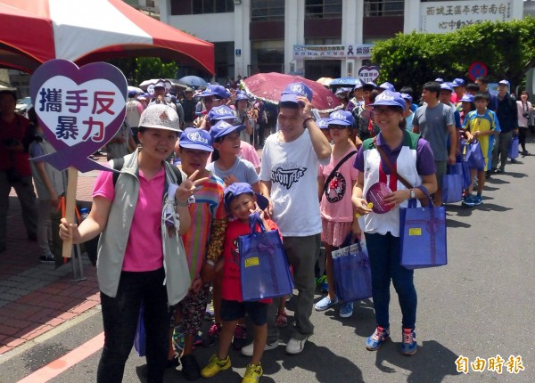 南市社會局舉辦紫色踩街嘉年華會，參與民眾頂著烈日宣導反家暴。（記者蔡文居攝）