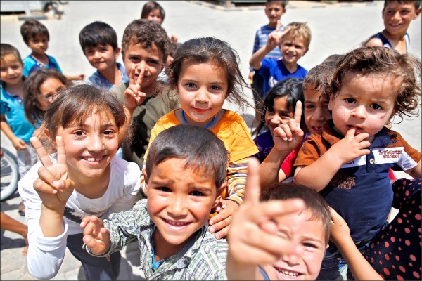 廿日為「世界難民日」，聯合國公布報告指出，全球多達六五三○萬人流離失所，等於每一一三人就有一人，「這是首度跨越六千萬門檻」。圖為土耳其東南部敘利亞邊界城鎮基利斯（Kilis）一座難民營，裡面收容的敘利亞兒童在鏡頭前展現天真無邪的笑容。（美聯社）