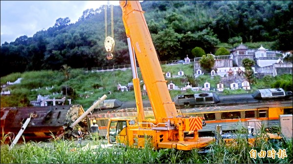 入夜後吊車出動，吊掛出軌車廂。
（記者花孟璟攝）