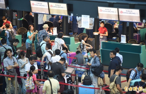 華航空服員罷工，導致今早6時到晚上10時的松山、桃園機場67航班全面取消，旅客不斷聚集在櫃台前向地勤人員抱怨。（記者劉信德攝）