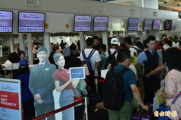 華航北部大罷工，南部機場也有受影響，旅客擠在高雄機場，不斷向華航櫃台洽詢。（記者張忠義）