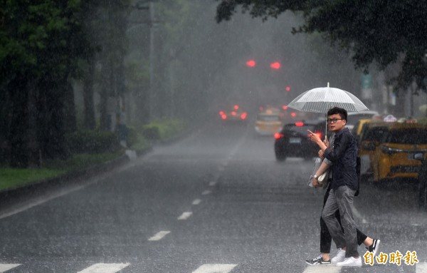 台北午後下起大雨，車輛行經低窪處濺起陣陣水花。（記者簡榮豐攝）
