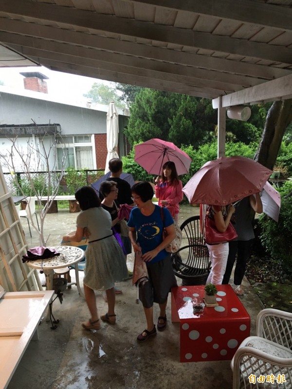 突然下起大雨，民眾紛紛開始躲雨。（記者楊綿傑攝）