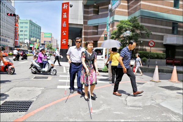 柯明期、陳錦純夫婦二月初向新莊區公所陳情捷運新莊站到公所路途障礙多，不利視障者行走，經過六次試走檢討，五月底終於獲得改善。（新莊區公所提供）