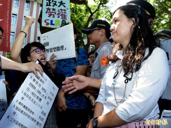 教育部高教司專員王淑娟（右）出面接受陳情，政大學生高若想（左）激動的高舉手中的雞蛋，在專員頭上捏破。（資料照，記者簡榮豐攝）