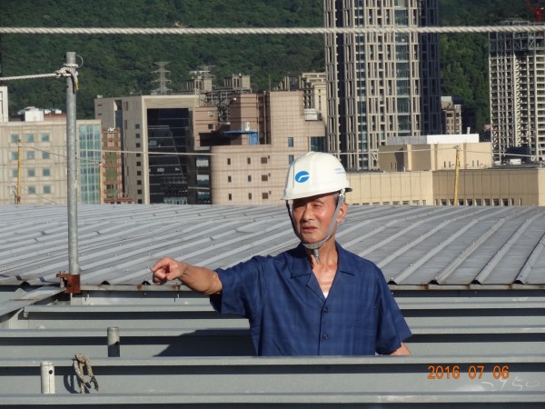遠雄集團董事長趙藤雄爬到大巨蛋屋頂，視察工程。（遠雄提供）