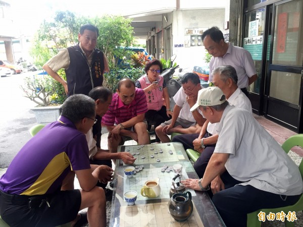 民眾常聚集泡茶聊天的市議員邱素貞服務處，颱風天，依舊來了近十位民眾下棋娛樂。（記者黃鐘山攝）