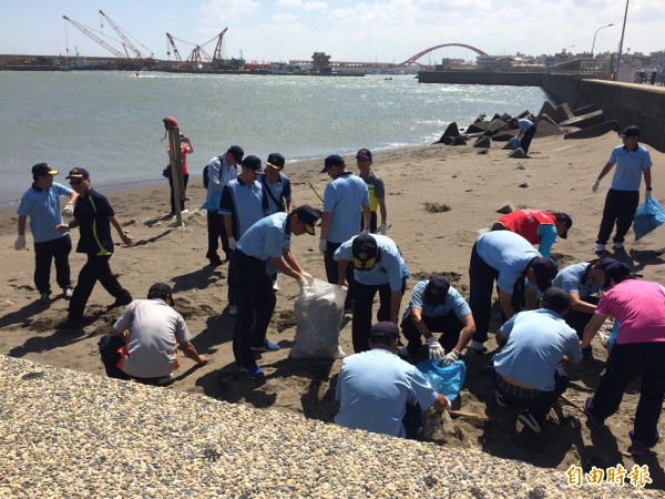 海巡署動員大批人員在竹圍漁港進行淨灘活動。（記者謝武雄攝）