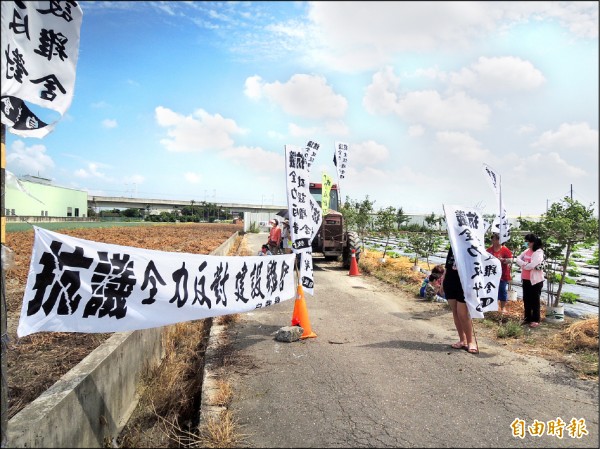 抗議設置養雞場，里民拉白布條抗議。（記者廖淑玲攝）