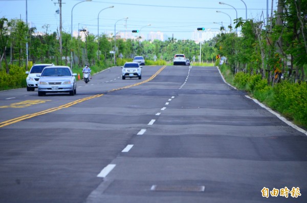 通車才年餘的道路，竟像「貼膏藥」一樣，到處補丁。（記者吳俊鋒攝）