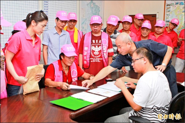 口湖鄉農會總幹事呂老乾（左坐者）昨天登記參選口湖鄉長補選。（記者黃淑莉攝）