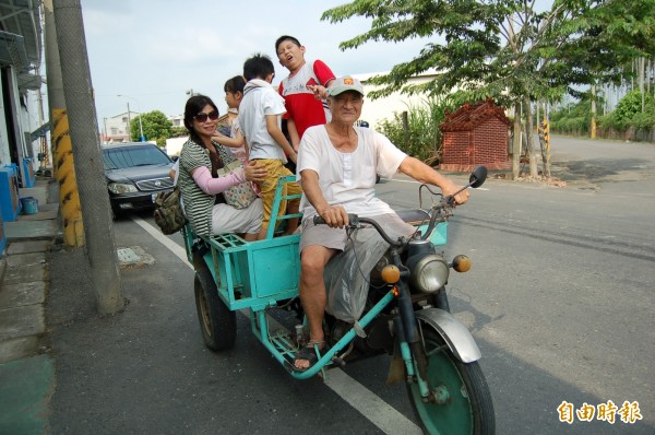 後壁無米樂辦活動，殷煌明（前）會駕駛動力三輪車載遊客遊菁寮。（資料照，記者楊金城攝）