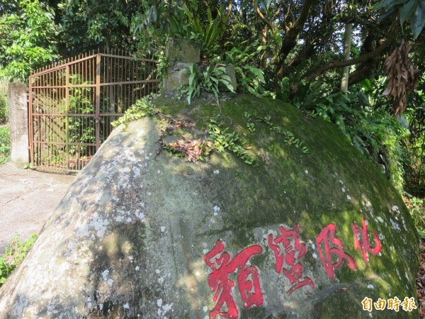 南投縣國定古蹟集集鎮「化及蠻貊」石碣，遭人在石碣另一端以水泥加蓋做成果園門柱。（記者劉濱銓攝）