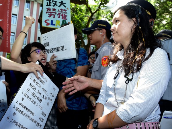 政大學生高若想（左）本月初抗議「學習型助理」，在教育部高教司專員王淑娟（右）頭上捏破雞蛋。（資料照，記者簡榮豐攝）