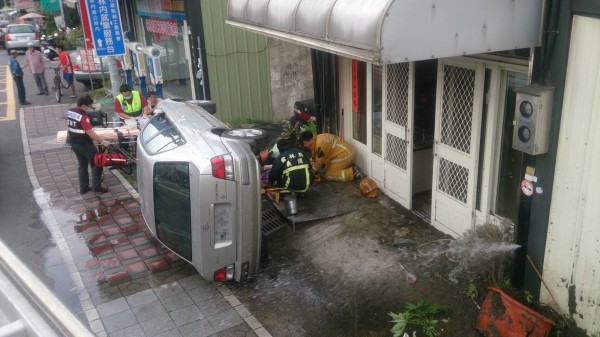 肇事轎車已被民眾翻起，救護人員對老婦進行搶救。（圖由雲林縣消防局提供）