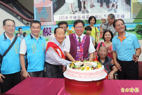 中壢區表揚模範父親，市長鄭文燦和103歲人瑞爸爸謝清占（前右二）一起切蛋糕。（記者李容萍攝）