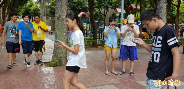 Pokémon GO開放台灣下載，路上行人全在低頭猛玩。（記者劉信德攝）