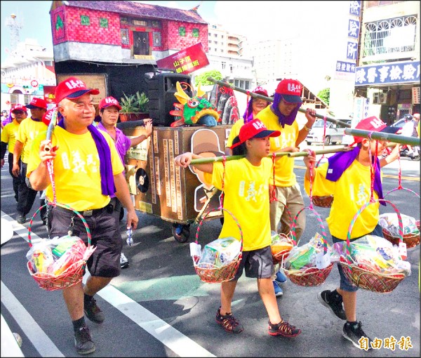 「桃園客家義民嘉年華」下午安排挑擔踩街，有不少年輕的「後生」晚輩前來體驗。（記者李容萍攝）