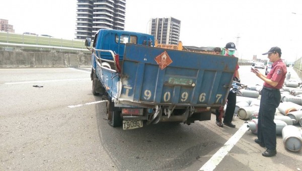 小貨車爆胎，車上的瓦斯桶散落一地。（記者曾健銘翻攝）