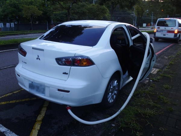 警方赫見路旁發動中的自小客正是稍早通報協尋車輛，且車輛排放的廢氣已經由塑膠管引進車內。（記者許國楨翻攝）