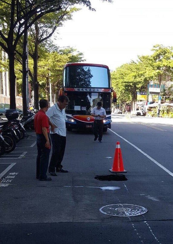 台中科大旁中華路今早疑因污水管破裂掏空，載滿大學生的遊覽車一停放就塌陷成路洞。（記者蔡淑媛翻攝）                        