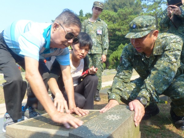 823老兵林德祿（左1）由女兒林秋子（左2）陪同，在金防部主任武立文少將（右1）協助下，找到老排長符國芳墓碑。（記者吳正庭攝）