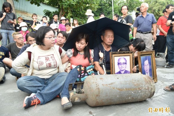 高雄市政府今天動員警力配合農業局拆遷牴觸果菜市場住戶，居民身綁鐵鏈、持桶裝瓦斯抗爭，宣示「死守家園、打死不退」，拆除現場氣氛緊繃。（記者張忠義攝）