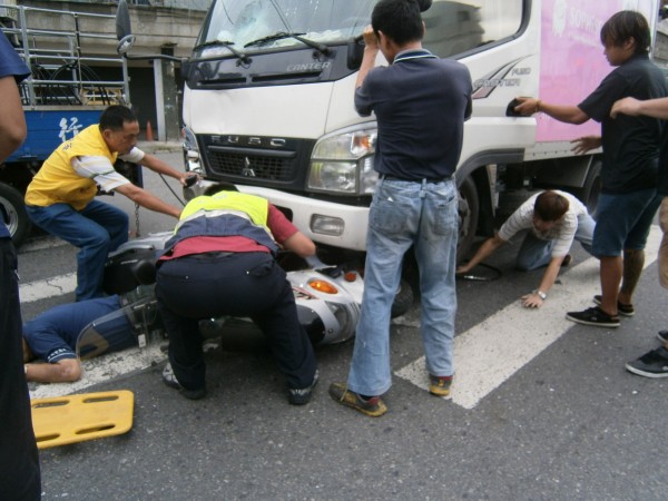 警消到場後趕緊將被車壓住的老翁救出。（記者劉濱銓翻攝）