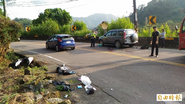 20多歲機車騎士疑因下坡過彎闖入對向車道，迎面撞上休旅車受困車底，大量出血生命跡象微弱，目前已脫困送醫急救。（記者余衡攝）