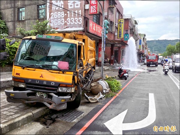 垃圾車撞消防栓 水噴2樓高。（記者余衡攝）