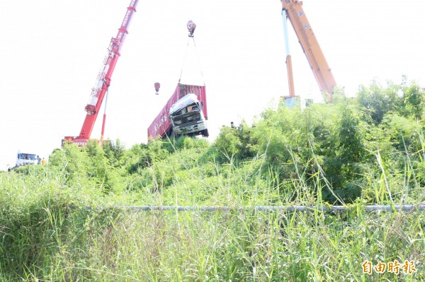 中山高麻豆戰備跑道貨櫃車翻落邊坡，動用大吊車調離。（記者劉婉君攝）