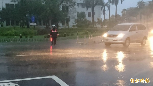 警員在大雨中堅守崗位，讓民眾很感動，但警眷卻很心疼。（記者王捷攝）