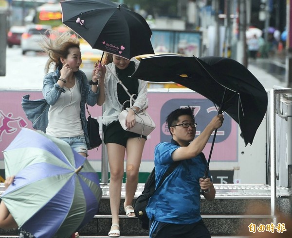 強颱莫蘭蒂重創南台灣，北台灣也正面臨中颱馬勒卡的威脅。圖為莫蘭蒂侵台時，強風陣雨將台北街頭行人的傘吹得變形。（資料照，記者廖振輝攝）